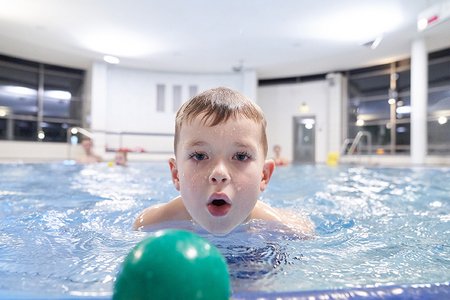 Junge im Wasser mit einem Ball.